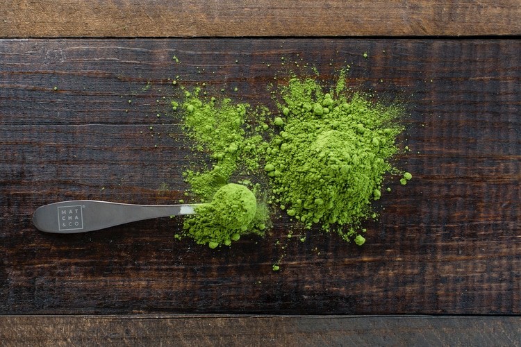 matcha powder in spoon and on table