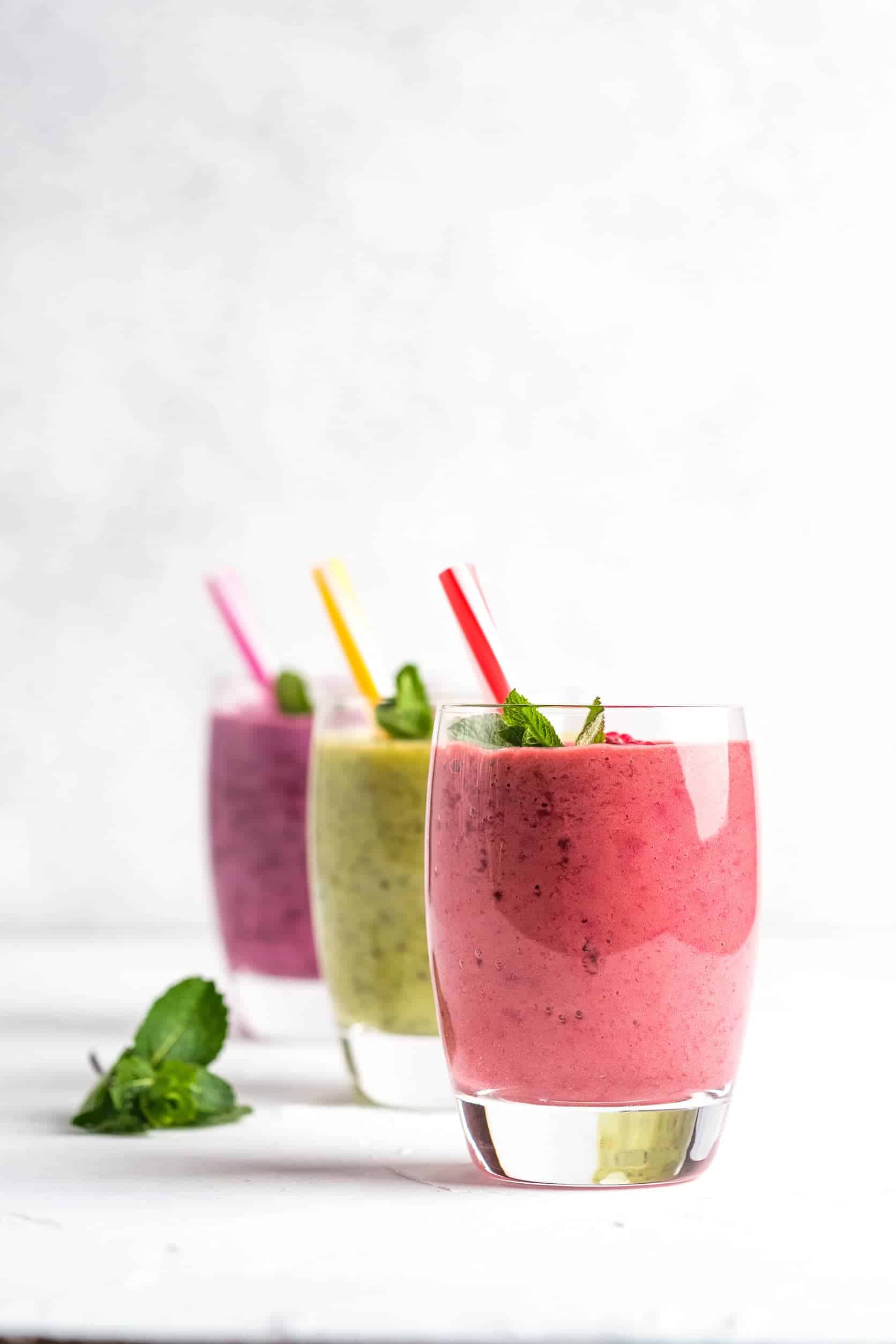 3 smoothies in glasses with straws