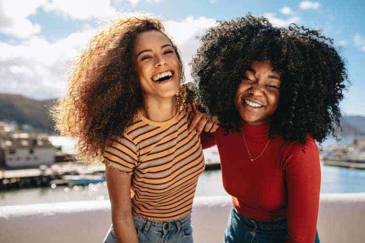 two women with long hair laughing