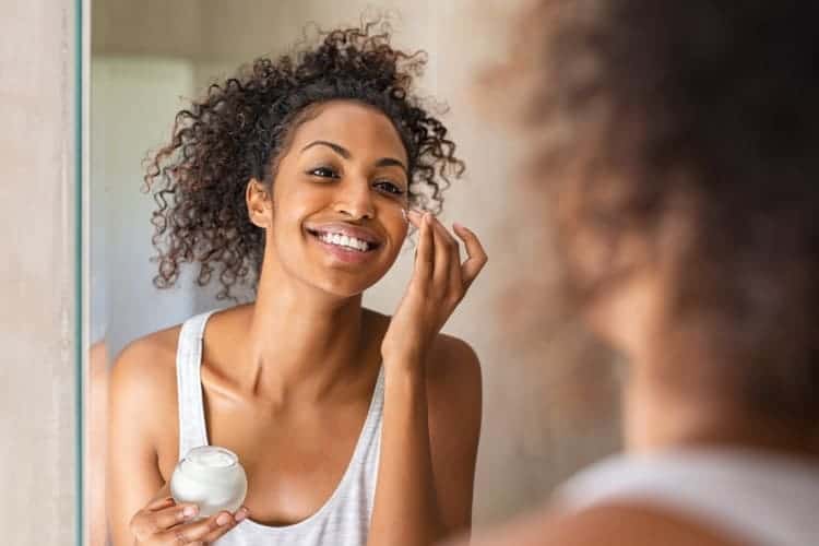 woman applying cream to her face